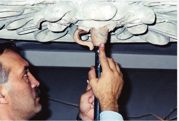 Nick fitting a cast ornament to a ceiling